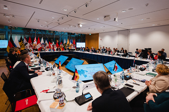 große Runde, in der Justizministerinnen und Justizminister mit Staatssekretären sitzen, im Hintergrund sieht man die Länderflaggen